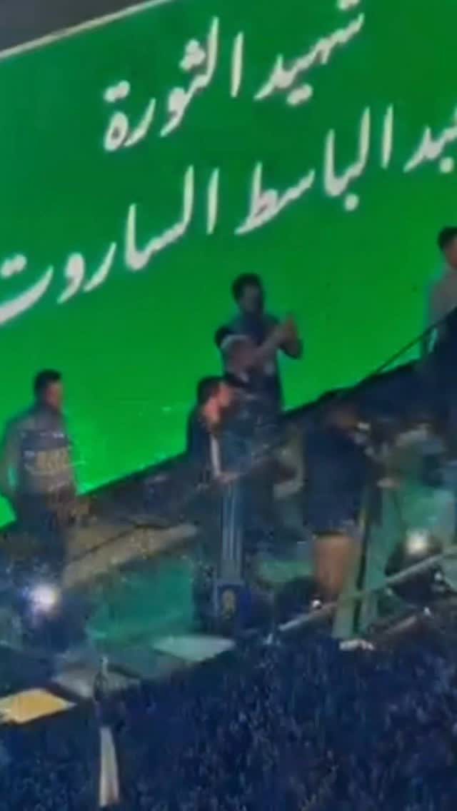 ماعم أعمل هالفيديو لحتى أحكيكم عن عيلة استثنائية، أنا هون لحتى أحكيلكم عن عيلة سورية عادية كتير، بتشبه عيلاتكم، وبيوتكم، وقصصكم. ببيتنا، كبرت وأنا عم شوف صور خمسة من أعمامي، ووالدي الشهيد، معلقة عالحيطان، تماماً متل ما آلاف البيوت من درعا لحلب، ومن حمص لإدلب والبلدات المنسية معلقة صور شهداءها . 

ومن بين هالصور، كانت صورة عمي عبد الباسط الساروت 

 عمي عبد الباسط ما خلق بطل، كان شاب سوري بسيط، عنده حنجرة دافية وحلم صغير بكرة القدم ومستقبل حالم .

 بس لما صرخت الشوارع بدها حرية، ترك شباك المرمى ليحرس أحلام الناس، وتحول صوته لمراية بتعكس وجع كل سوري. 

عاش عمي ثائر، كان يغني للبلاد وللناس و يقاتل كرمال الحرية ، وما طلب لحاله شي غير إنه يشوف السوريين أحرار. 

وبمعارك ريف حماة، بسنة ٢٠١٩، استشهد متأثر بجراحه، ليلحق بوالدي و عمامي ، ويكمل عقد التضحية بعيلتنا.

 بس أنا اليوم، وكابن لهي العيلة يلي قدمت يلي قدمته، بقلكن إياها من كل قلبي دماء عمي عبد الباسط، ودماء أبي وأعمامي، مالها أغلى ولا أطهر من نقطة دم وحدة نزفت من أي شهيد أو شهيدة على أرض سوريا.

 الساروت ما كان عم يأنشد لحاله، ولا لعيلته، كان صوت للمظلومين، وحنجرة للناس يلي غيبتها السجون والمقابر الجماعية. 

كل شهيد راح بهي الثورة، من الطفل يلي اتهدم بيته فوق راسه، للشاب يلي قضى تحت التعذيب، للمقاتل يلي ثبت بخندقه، هدول كلهم أعمامي، وكلهم أبائي، وكلهم ال